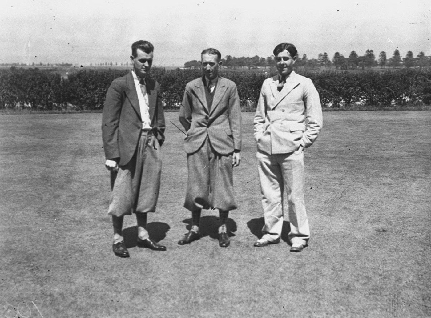 Three golfers in the 1920s, two in jackets and plus fours and one in a pale suit