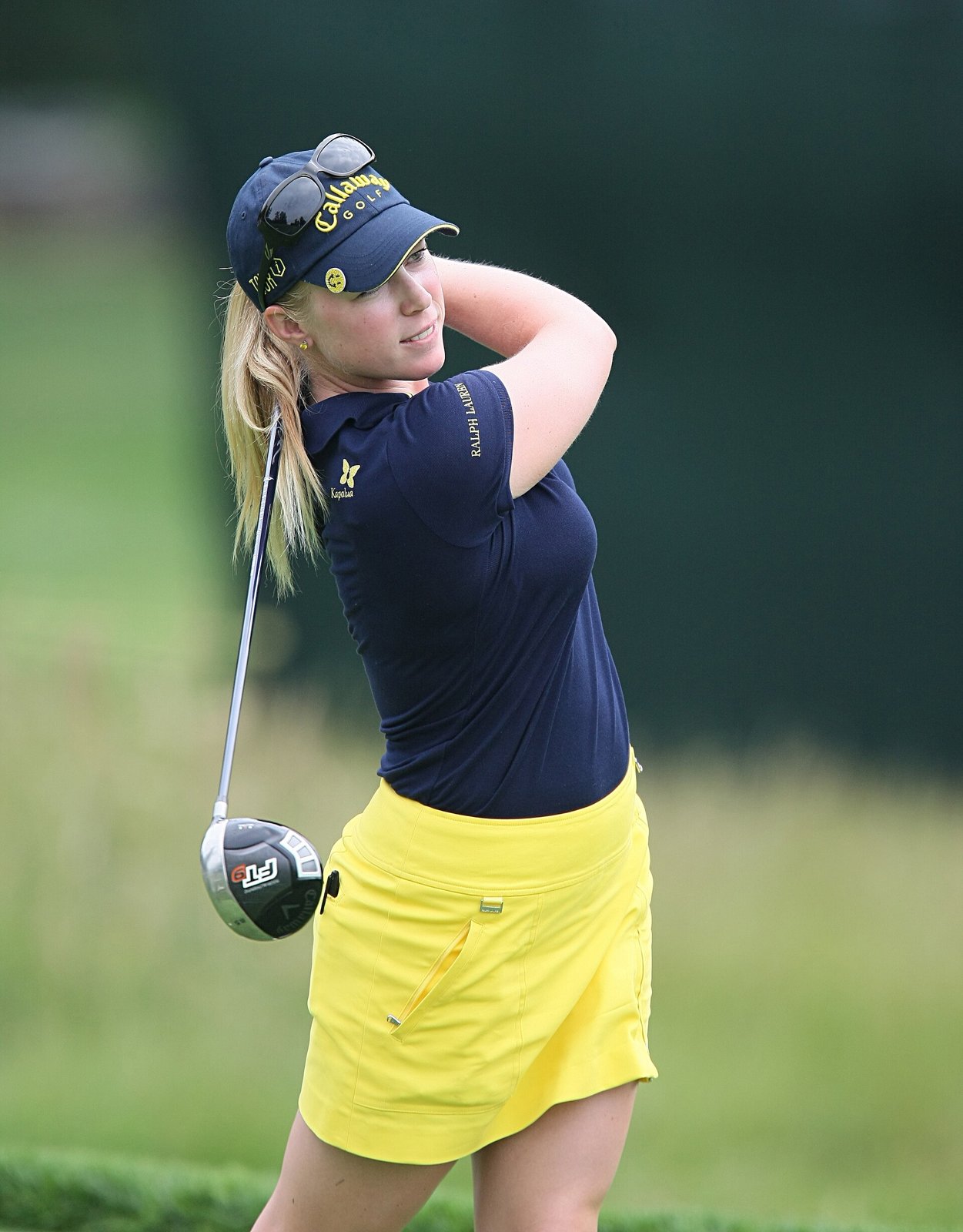 Morgan Pressel following through in a yellow skort and navy polo at the 2009 LPGA Championship pro-am