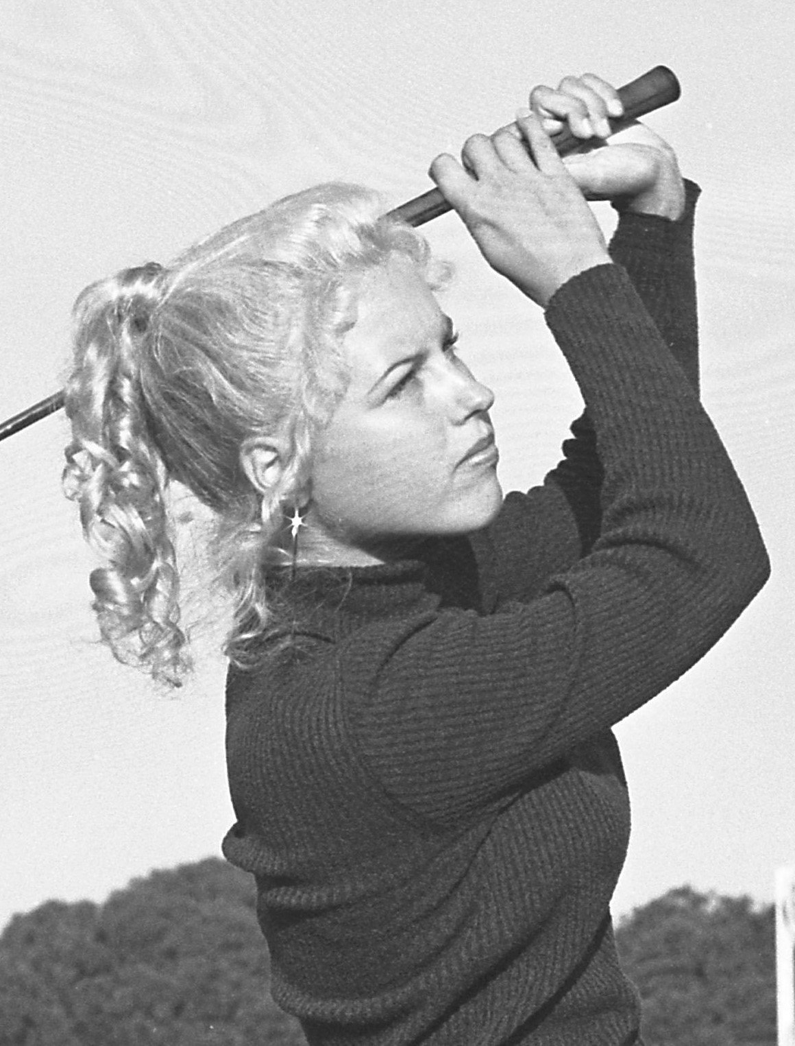 Laura Baugh at 16 in 1972, mid-swing in a ribbed turtleneck sweater, her hair in a curled ponytail