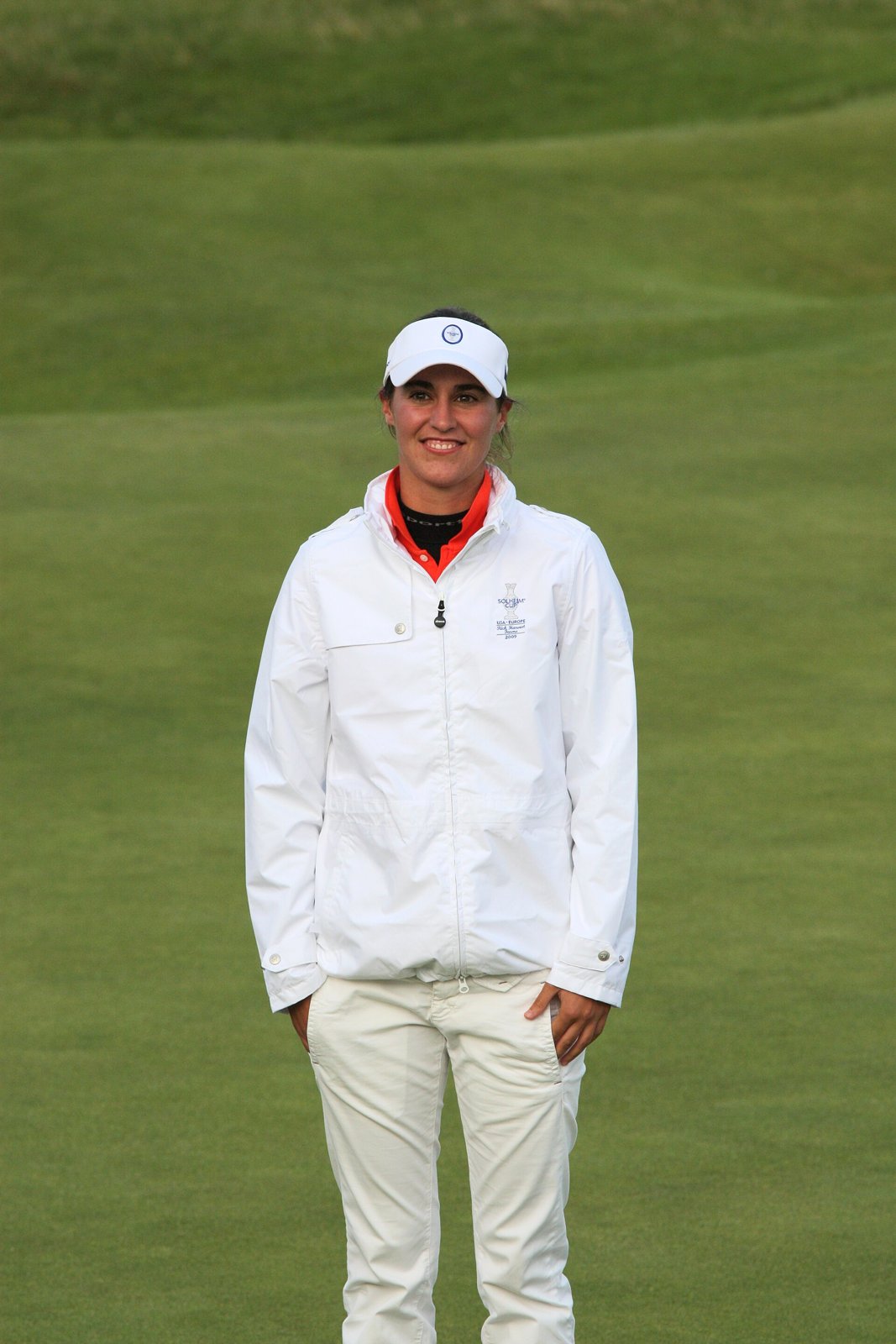 Tania Elosegui at the 2009 Solheim Cup in white golf trousers, a white team jacket and a white cap